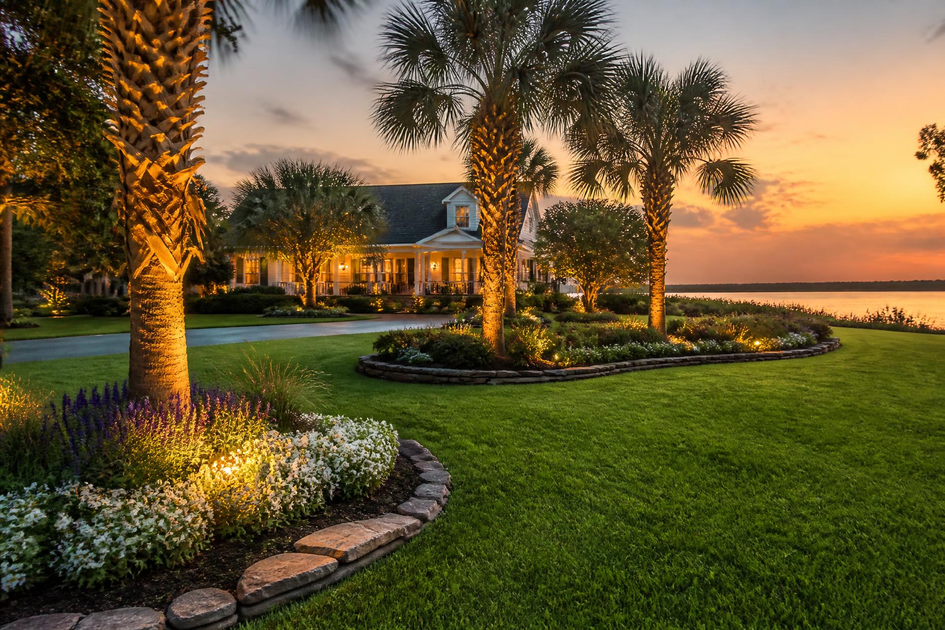 Manicured South Carolina landscape with stone-edged flower beds and palms